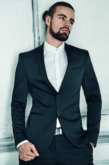 Photo gratuite portrait de beau modèle élégant homme d'affaires hipster vêtu d'un élégant costume noir.