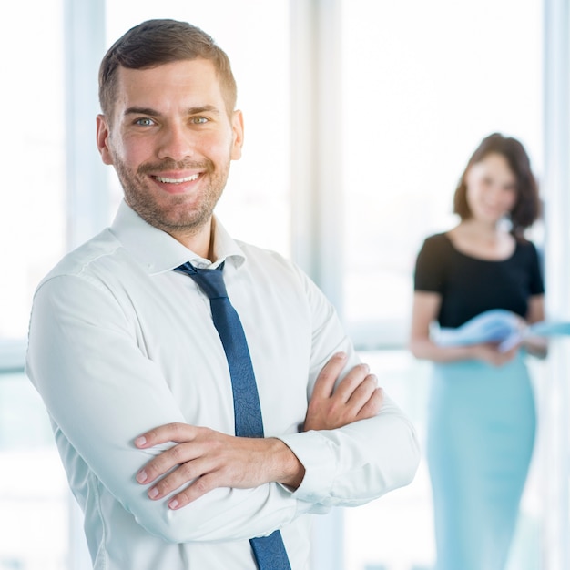 Photo gratuite portrait d'un homme d'affaires heureux avec les bras croisés