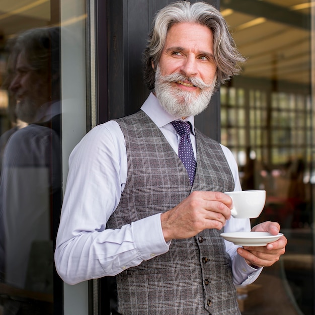 Photo gratuite portrait d'homme élégant appréciant le café