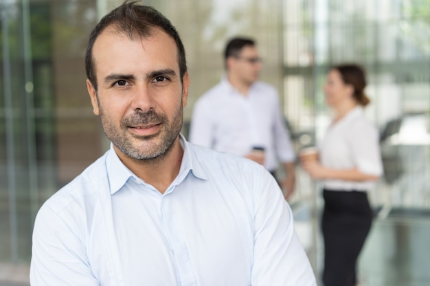 Photo gratuite visage d'un homme heureux exécutif regardant la caméra et souriant