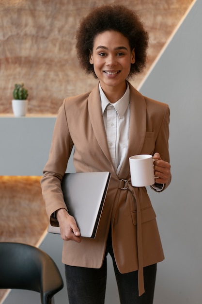 Photo gratuite vue de face femme économiste tenant un ordinateur portable