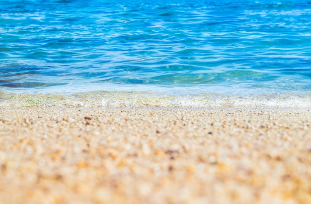 Foto chiuda sull'onda del mare blu sulla spiaggia della spiaggia di sabbia