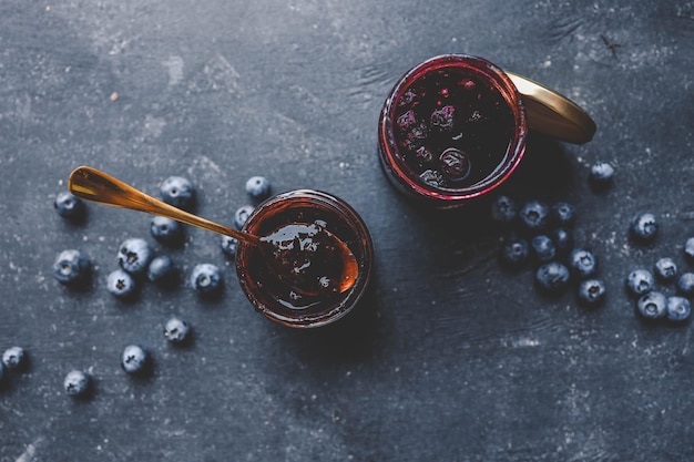 Foto deliziosa marmellata di mirtillo biologico su uno sfondo scuro