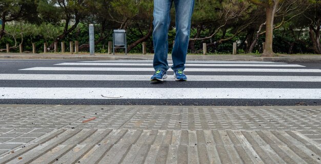 Foto sezione bassa di una persona che cammina sul passaggio pedonale