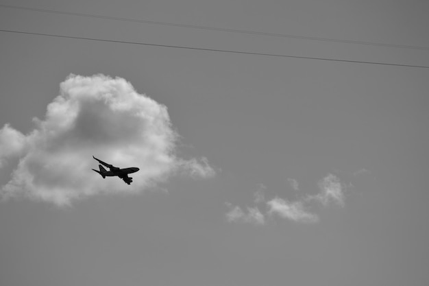 Foto un aereo sta volando nel cielo e le nuvole sono sullo sfondo.