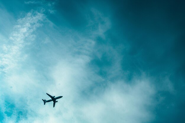 Foto un aereo sta volando attraverso il cielo con una nuvola nel cielo