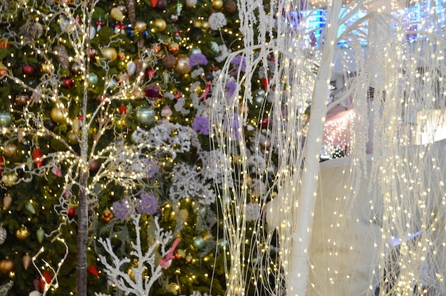 Foto decorazione della vetrina del negozio centro commerciale decorazione artificiale abete bianco con ghirlande vicino