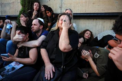 Jahresrückblick: Friends and family take cover as rocket sirens sound during the funeral of Sagiv Ben Zvi, 24, who was killed following the deadly infiltration by Hamas gunmen from the Gaza Strip as he attended the Nova festival in southern Israel, in Holon, Israel, October 26, 2023.