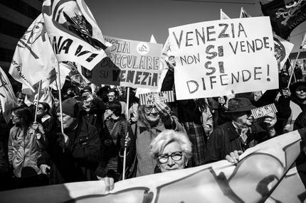 Overtourism in Venedig: Protestors hold banners as they take part in a demonstration against the new "Venice Access Fee", organised by the list "Tutta la citta' insieme" (The whole city together) and members of several Venetians trade associations in "Piazzale Roma" in Venice, on April 25, 2024. Venice launched a new scheme to charge day-trippers for entering the historic Italian city, a world first intended to ease the pressure of mass tourism , but many residents are opposed, in Venice, on April 25, 2024. (Photo by Marco BERTORELLO / AFP) (Photo by MARCO BERTORELLO/AFP via Getty Images)