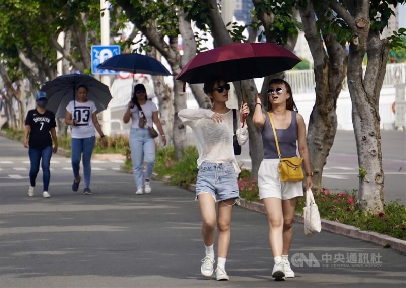 圖為高雄市鹽埕區民眾撐傘出遊。中央社記者董俊志攝 112年6月8日