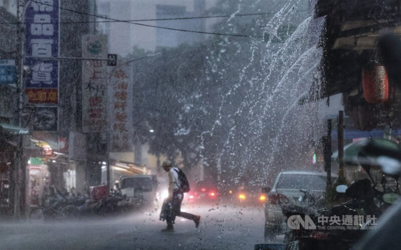 中央氣象署8日下午針對大台北等17縣市發布大雨特報。圖為台北市內湖區未帶傘具的民眾，頂著雨勢快步穿越馬路。中央社記者王飛華攝 113年7月8日