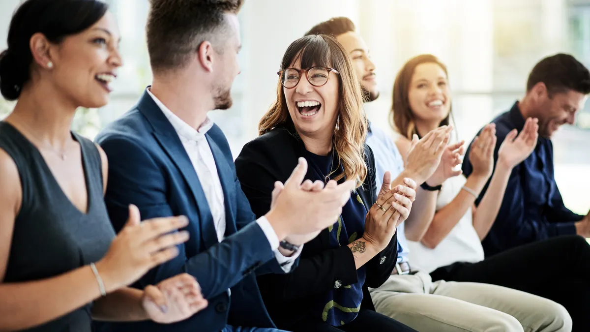 Group of businesspeople applauding during a seminar.