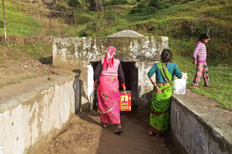 Seema Devi and other women from her village line up at the aquifer beneath the newly constructed field that doubles as a helipad.