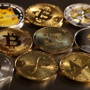 A imagem mostra algumas criptomoedas juntas, como bitcoin e dogecoin.