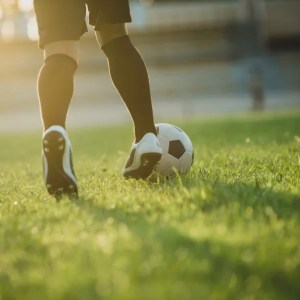 Imagem de um jogador de futebol com uma bola para ilustrar reportagem sobre como se preparar financeiramente para curtir a Copa do Mundo de 2030