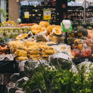 Imagem da área de hortifruit de um supermercado com diversas verduras e legumes expostas.