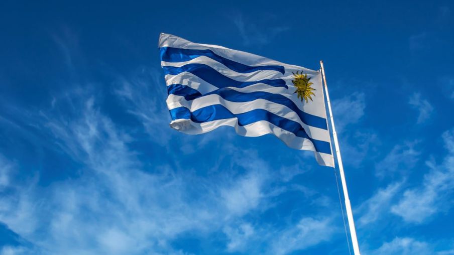 Foto da bandeira do Uruguai em um céu azul.