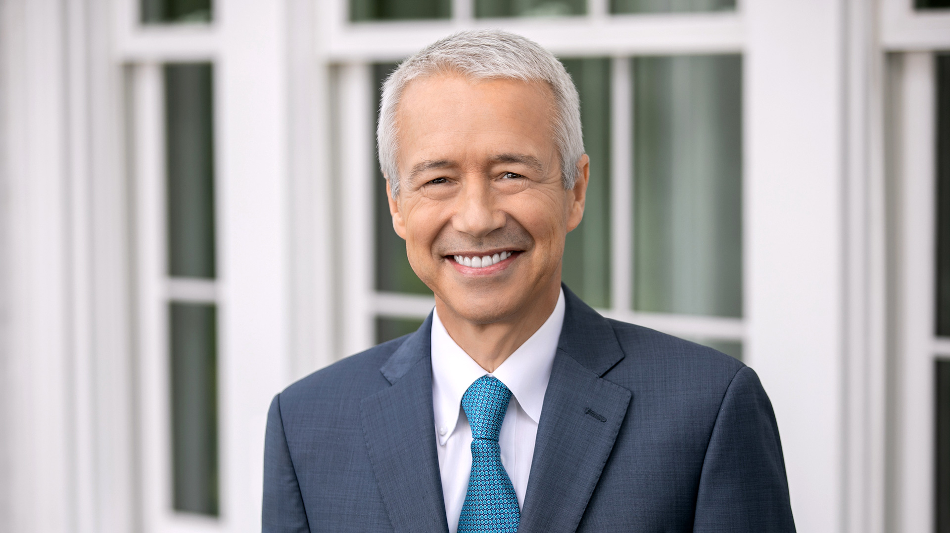 Headshot of Johnson & Johnson's CEO and Chairman of the Board Joaquin Duato wearing a navy blue suit and bright blue tie 