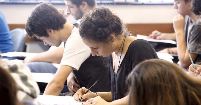 Estudantes numa sala de aula fazendo prova do vestibular