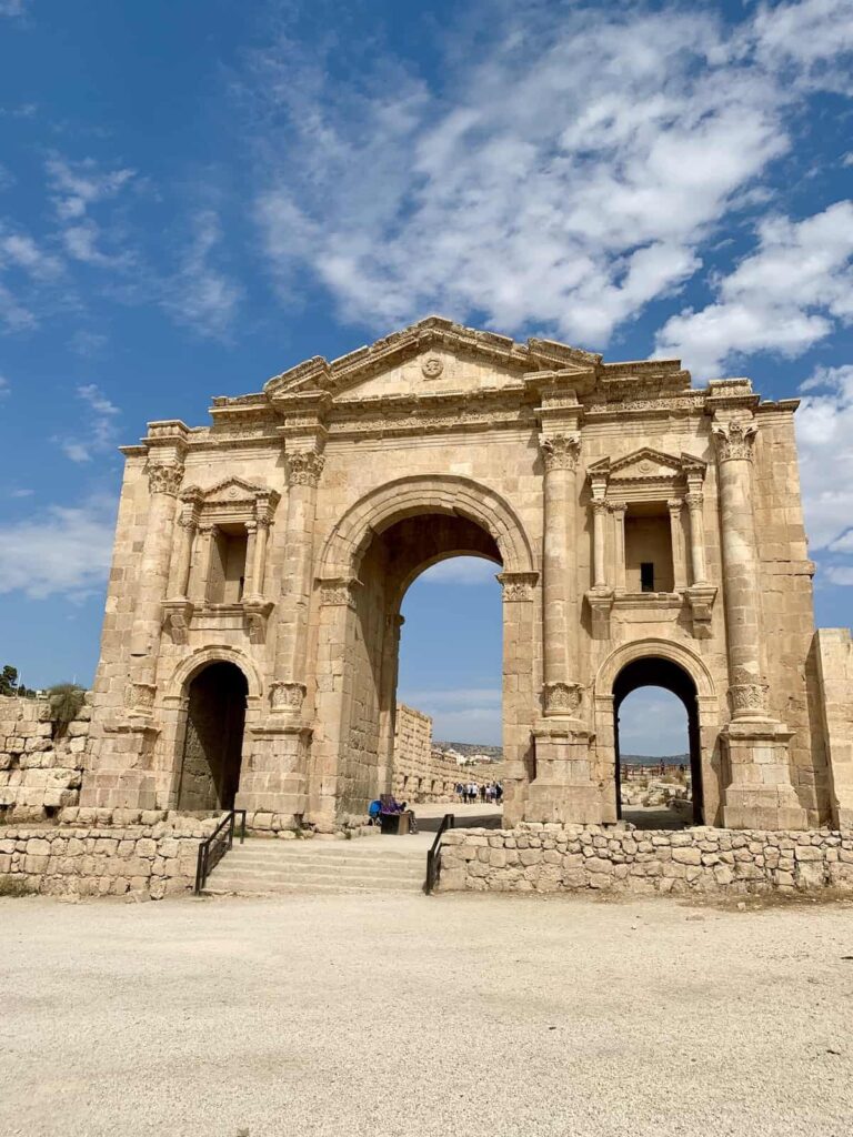 Hadrian's Arch in Jerash Jordan with blue sky in background.