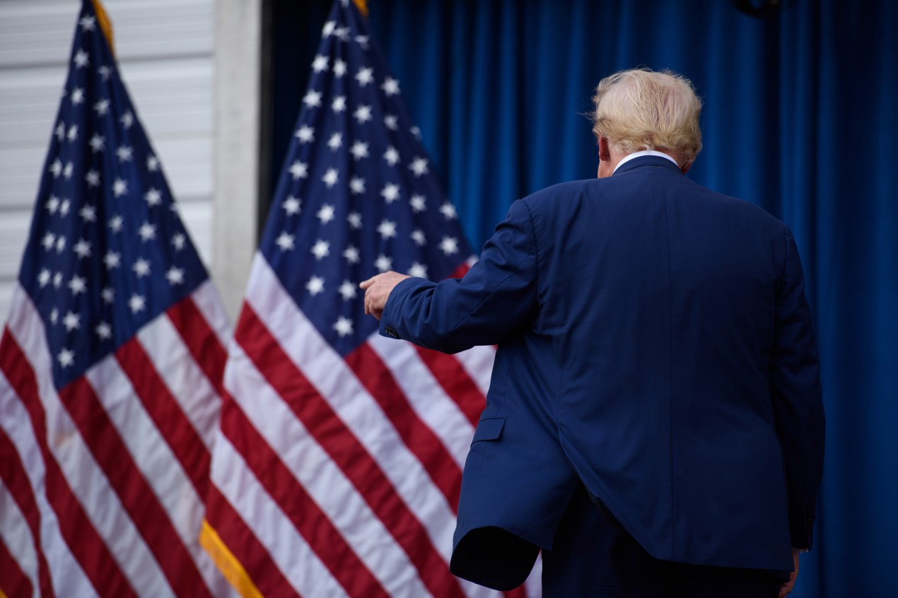 A photograph of the back of President-elect Donald Trump as he walks away from the camera.