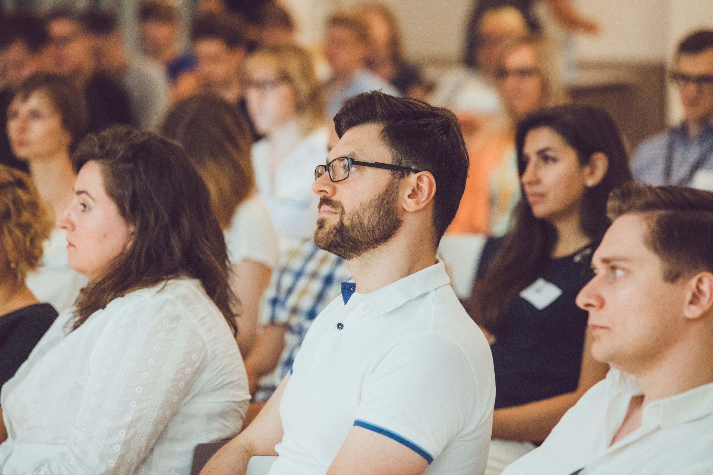 A man in conference listening to speaker.