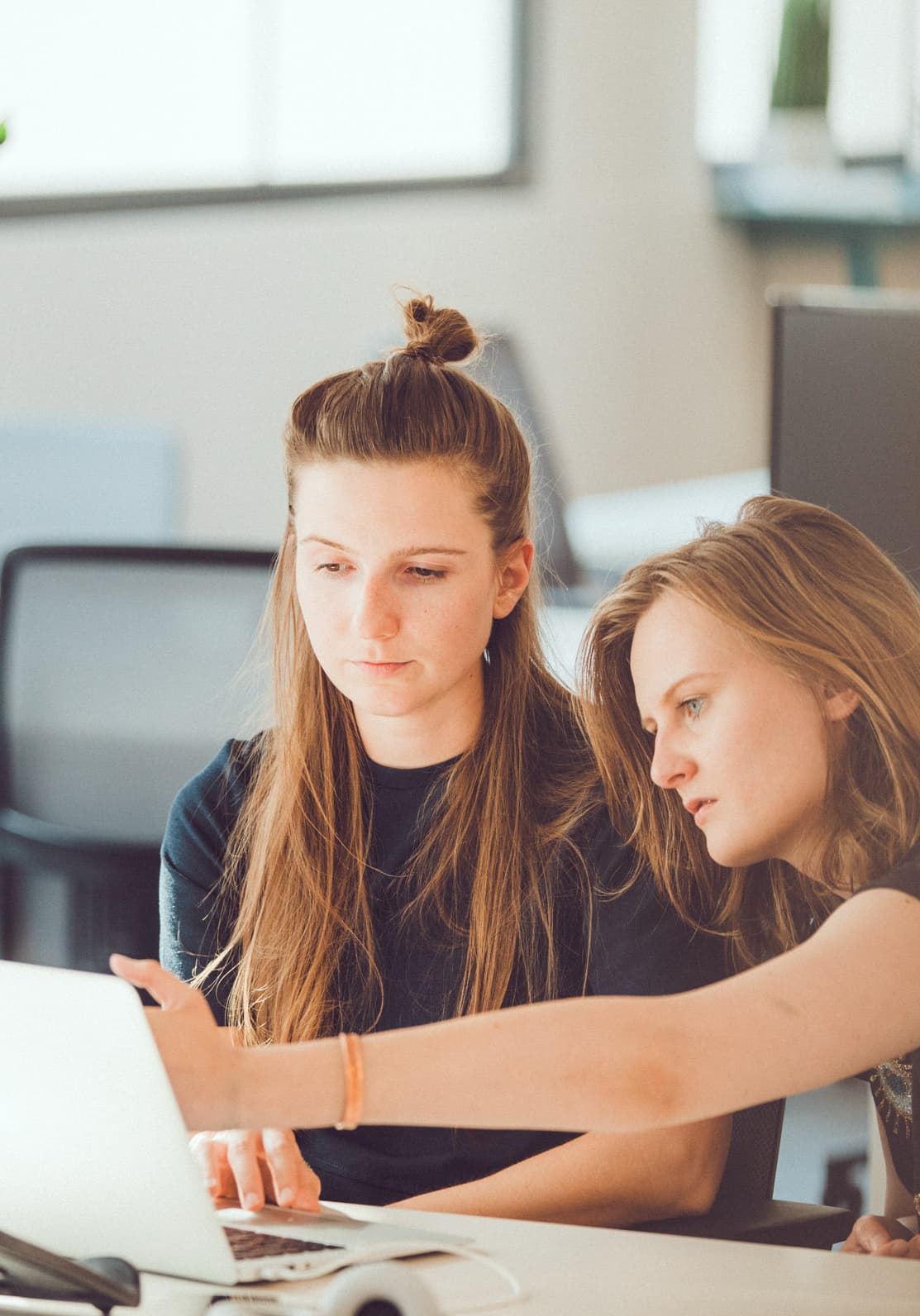 A women showing something in laptop to another women.