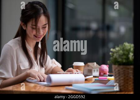 Portrait asian businesswoman or lawyer accountant working financial investment on office, using calculator analysis finance document report real Stock Photo