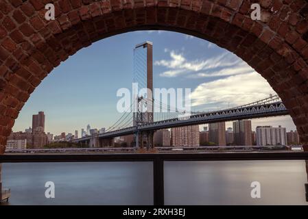 Framed view about the Manhattan bridge what connecting Brooklyn to Manhattan. This is a 2 levels bridge for subways, busses cars and trucks. Stock Photo