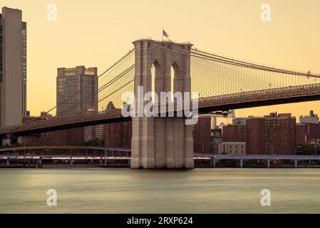 Amazing golden hour view about the Giant Brooklyn bridge over the East river in New York city. This bridge connects Manhattan and Brooklyn. Stock Photo