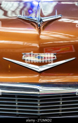 Logo and eagle bonnet mascot at the front of 1950s Chevrolet Bel Air, Autoworld museum, Brussels, Belgium Stock Photo