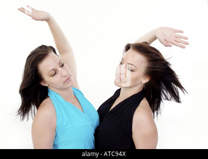 twin sisters standing close together, high five Stock Photo