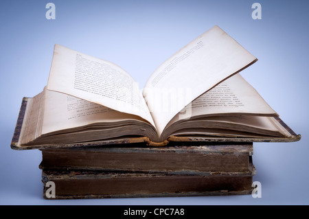 stack of old book, one opened on top Stock Photo