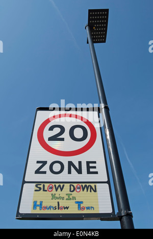 british road sign indicating 20mph zone with local wording beneath stating slow down you're in hounslow town Stock Photo