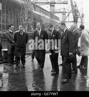 Prince Philip, The Duke of Edinburgh, visiting the new giant Cunard liner Q4, is shown around John Brown's Shipyard, Clydebank, Scotland today by Lord Aberconway, Chairman of John Brown's (centre), with Mr. John Rannie, John Brown's Managing Director (right). The Duke was visiting the shipyard for his first sight of the Q4 which the Queen is to name and launch on September 20. Stock Photo