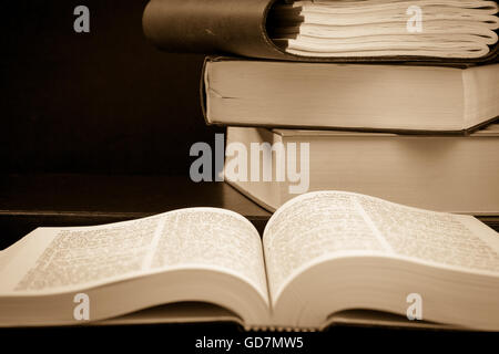 Stack of old books, one is opened, retro look, copy-space Stock Photo