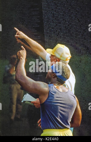 Two men looking for a name on the Vietnam Memorial Wall. Stock Photo