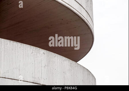 Side view of a circular ramp to a parking garage. It is tan and made of cement blocks on the outside, cement slabs on the inside. It is a multi-level  Stock Photo