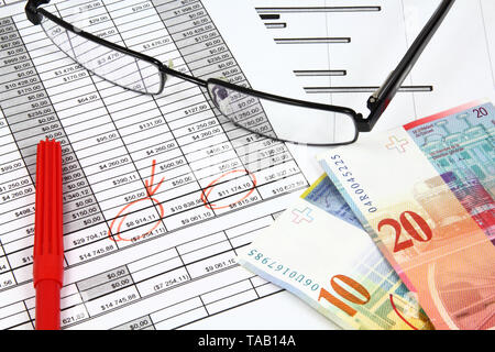 Business composition. Financial analysis - income statement, finance graphs, Swiss frank money and glasses. Stock Photo