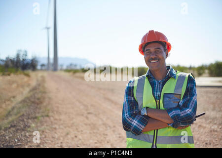 Porträt Lächeln Ingenieur auf Feldweg bei Wind Turbine Kraftwerk Stockfoto