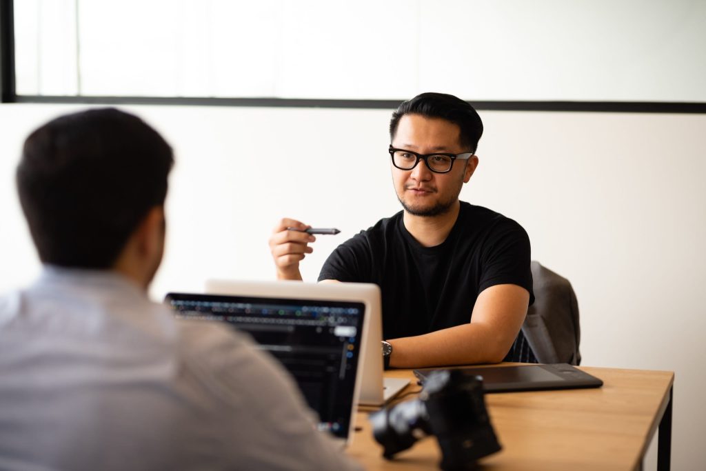 Men sitting across from each other at desk