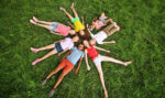 Kids lay in the grass together