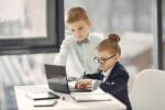 Young professional kids looking at a computer