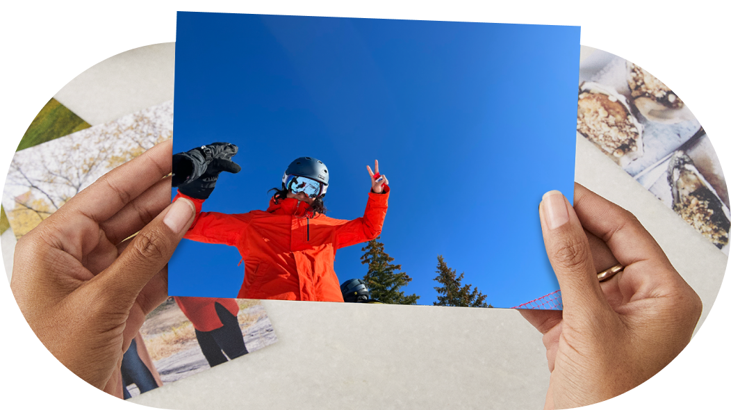 A photo print of a skier holding up a peace sign under a blue sky. 