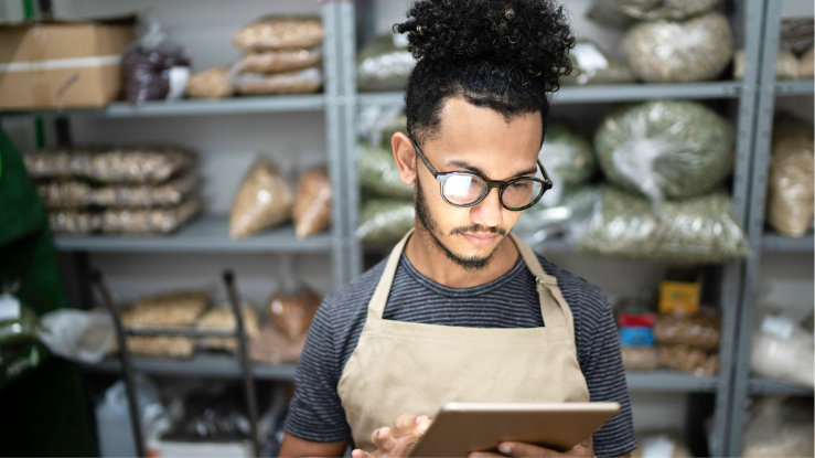 Person on a tablet device in a restaurant storage room
