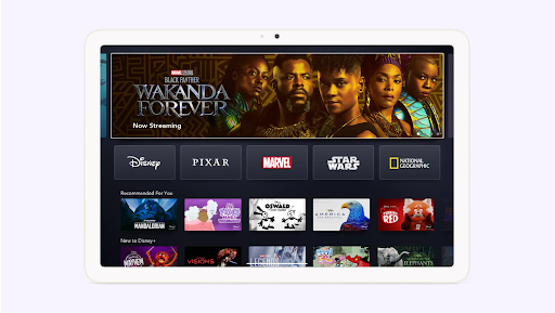 Une tablette affiche la page d'accueil de Disney+ avec les séries et films recommandés.