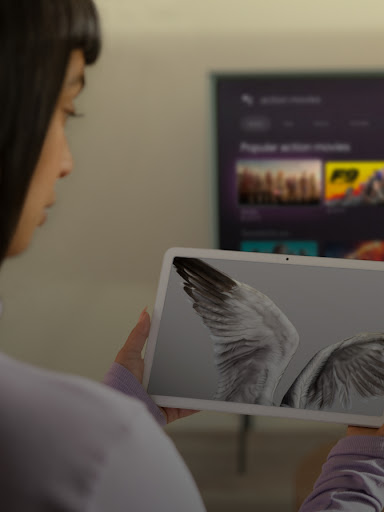 An Android user watches a video on their tablet. In the background YouTube is on their TV.