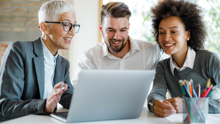 Three people discussing a sales pitch on a laptop.