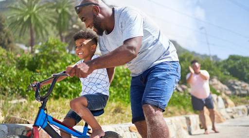 photo of a man and child riding a bike