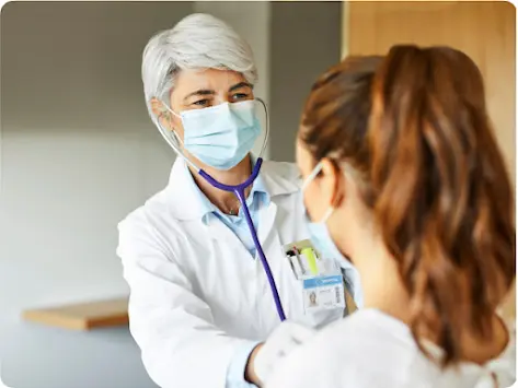 Un médico escucha los latidos cardíacos de un paciente.